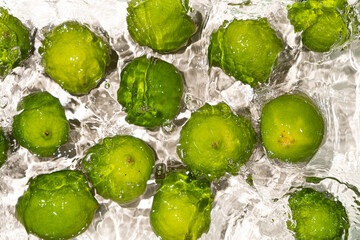 Fresh Whole Limes Floating in Water Top View