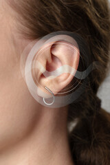 Sound waves and ear anatomy illustrated on a persons ear for educational purposes in a clinical...