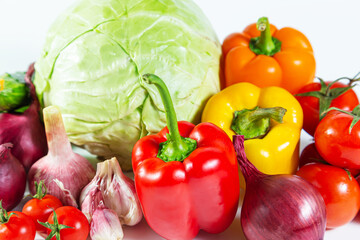 Mix of colorful vegetables - bell pepper, cabbage, tomatoes, cucumbers, onions and garlic. Isolated on white.