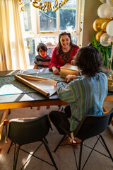 Adult siblings with little sister wrapping gifts for Eid Celebration
