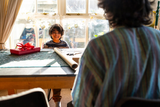 Young man with little sister preparing gifts for Eid Celebration