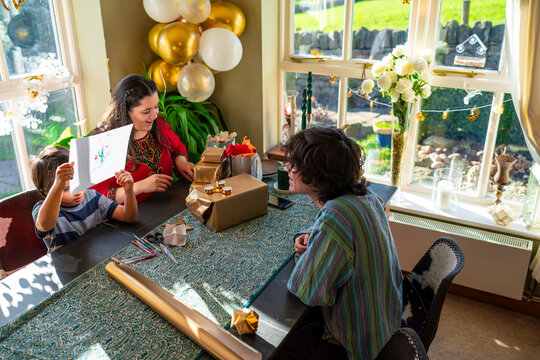 Adult siblings with little sister preparing gifts for Eid Celebration
