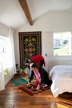 Mother with adult daughter praying during Eid Celebration