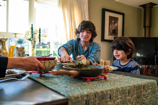 Young man with little sister dining during Eid Celebration