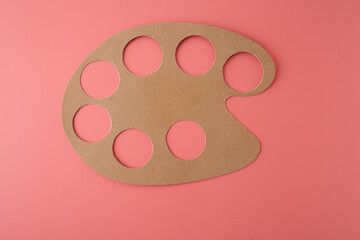 Painted cardboard palette with colorful circles for kids DIY craft on pink background, great for kindergartens, educational platforms, creative courses, and hands-on early childhood programs.