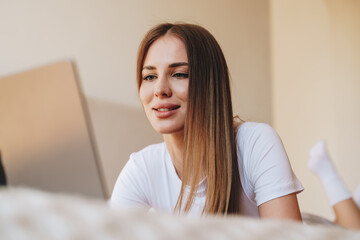 Young woman working intently on a laptop while relaxed at home in the afternoon light