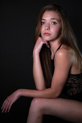 posing on elbows against a black background