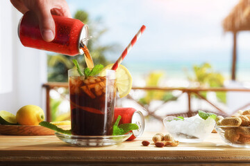 Drinking cola on table with appetizers on beach terrace