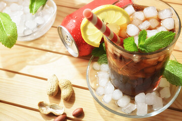 Cola soda on wooden table with appetizers on sunny day