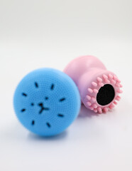 Silicone washing brushes.Blue and pink facial cleansing brush on a white background. The concept of beauty and skin care. Face Lifting, Wrinkle Smoothing and Massage brush