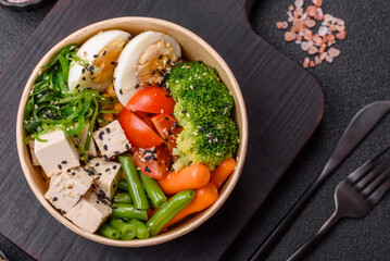 Vegan salad, bowls with chickpeas, broccoli, tomatoes, tofu cheese and boiled eggs