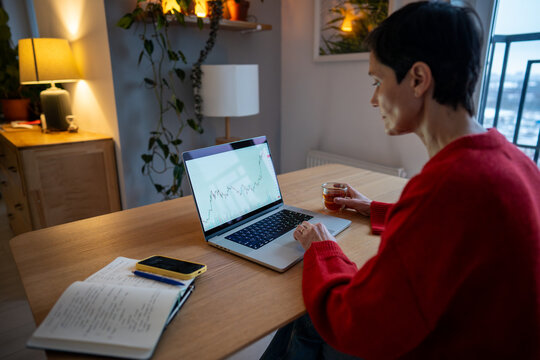 Senior woman working on laptop. analyzing stock exchange charts and cryptocurrency market trends using online platform. Monitoring investments, tracking digital currency fluctuations, market analysis