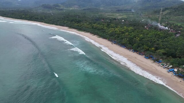 Aerial drone view of red island east java indonesia tropical beach surfers ocean waves