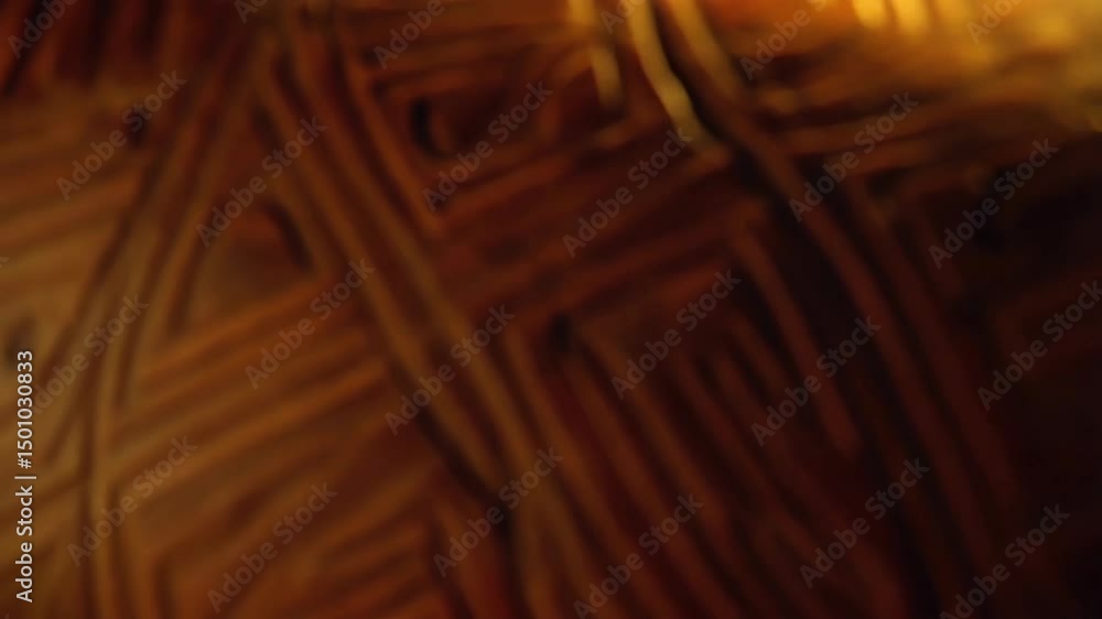 Poster close-up of carved brown earthen pottery with repeating geometric patterns and textures illuminated 