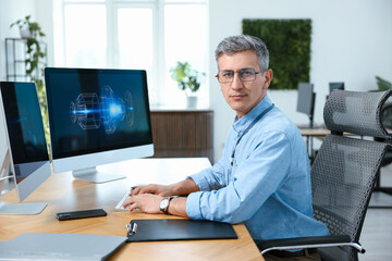 Engineer working with digital drawing at table in office