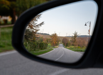 Rural empty road seen through car side mirror in Abruzzo, Italy