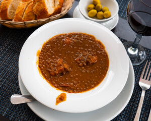 Delicious lentil soup with meat and vegetables served to table