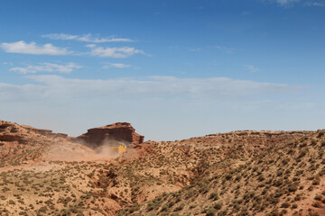 SUV car moving on dusty road at Pingshan Hu Grand Canyon in summer, Zhangye City, Gansu Province in China