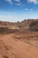 Naklejka premium SUV car and quad bike moving on dusty road at Pingshan Hu Grand Canyon in summer, Zhangye City, Gansu 