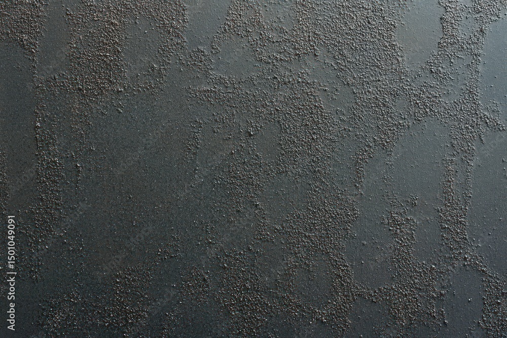 Aufkleber close-up of dark rough textured surface with scattered small granules creating a rugged pattern