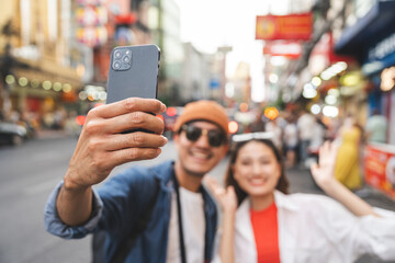 Asian couple man and woman enjoy eating street food noodle at night market. Traveler Asian couple blogger Happy tourists with Traditional food local road at thailand bangkok city.