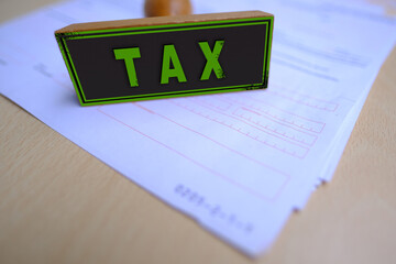 Wooden Tax stamp on financial documents, symbolizing fiscal responsibility and compliance, concept...
