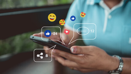 Close-up of hand using smartphone with social media icons, likes, comments, and shares,...