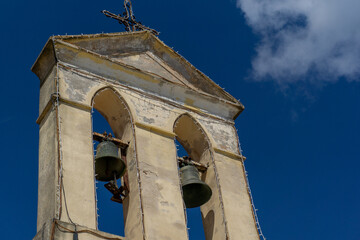 Campanile con due piccole campane che si staglia contro un cielo azzurro
