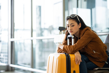 Unhappy young woman traveler disappointed with flight delay or cancelation while waiting at airport terminal, female tourist upset after receiving bad news when sitting at airline lounge.