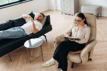 Man is lying down at couch and talking, at psychologist appointment