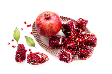 Top view of fresh ripe pomegranate and pieces on plate for eating, top view.