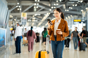 Portrait of confident young businesswoman smiling at camera ready traveling business trip with holding passport with ticket boarding pass and smartphone at the international airport terminal.