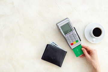 Hands holding Pos bank terminal for payment by credit card, bill for cup of coffee in cafe