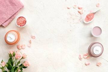 Homemade organic cosmetic with roses essential oil. Face cream with flowers and petals, top view