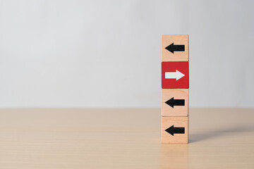 Red cube with white arrow facing opposite black arrows. Symbol of leadership, thinking differently,...