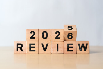 Turning wooden cube from Review 2025 to Review 2026. Concept of business review, new year planning,...