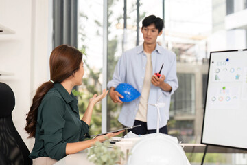 Engineer Explaining Project Details. A female engineer discusses plans with a colleague in a bright office.