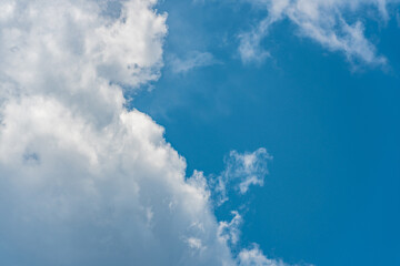 Fluffy white clouds in a bright blue daytime sky