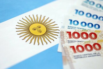 Argentine pesos money bills in big amount lies on Argentina flag close up