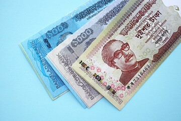 Bangladeshi taka money bills in big amount lies on teal color table close up