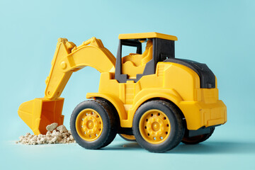 A small yellow toy excavator is digging up debris on cyan background