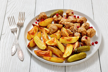 meatballs, potatoes, pickles, berries on a plate
