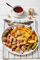 meatballs, potatoes, pickles, berries on a plate