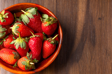Fresh and Juicy beautiful organic strawberries on wooden background. Top view point.