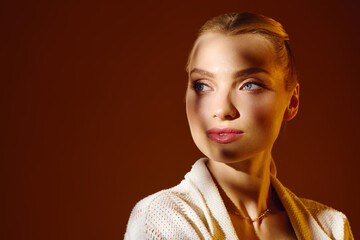 Young beautiful woman showcasing elegance and style with warm light accentuating her features