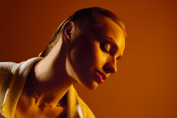 Young woman exudes beauty and elegance against a warm backdrop during a fashion inspired moment