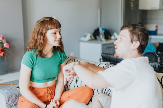 Two friends discuss with enthusiasm in a modern apartment, conveying connection, earnestness, and a relaxed social environment