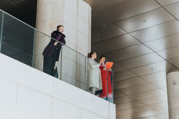 Professional women standing indoors in a modern space, engaging in discussions and highlighting...