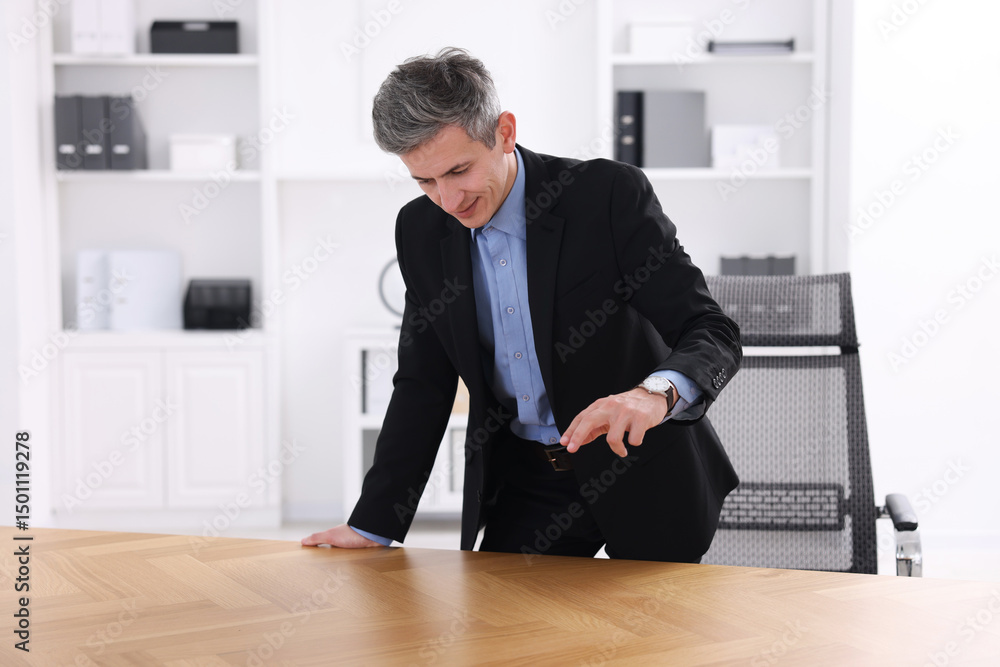 Poster man pointing at something on desk in office