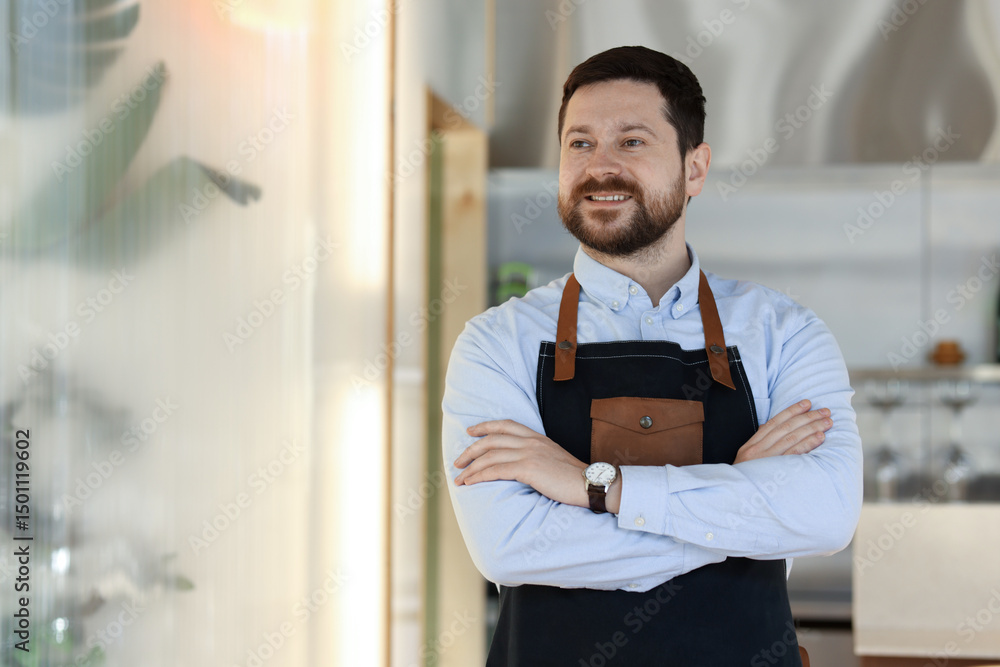 Poster smiling business owner with crossed arms in his cafe. space for text